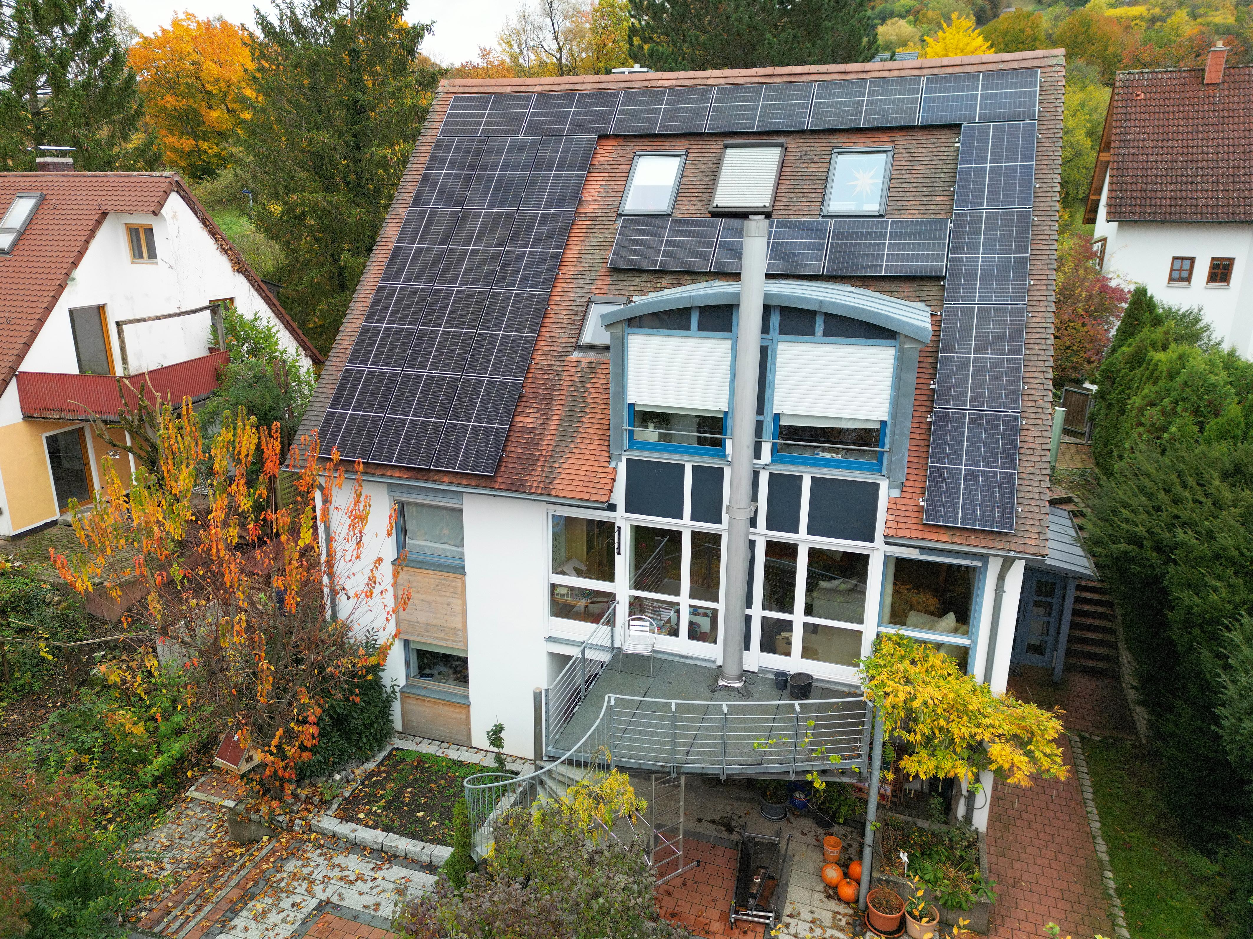 Eine Photovoltaikanlage auf einem Haus mit Erker und Dachflächenfenstern.