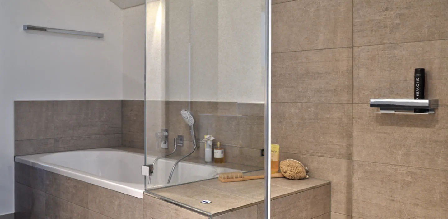 Bild einer Badewanne in einem modernisierten Wohnbad mit Dampfdusche.