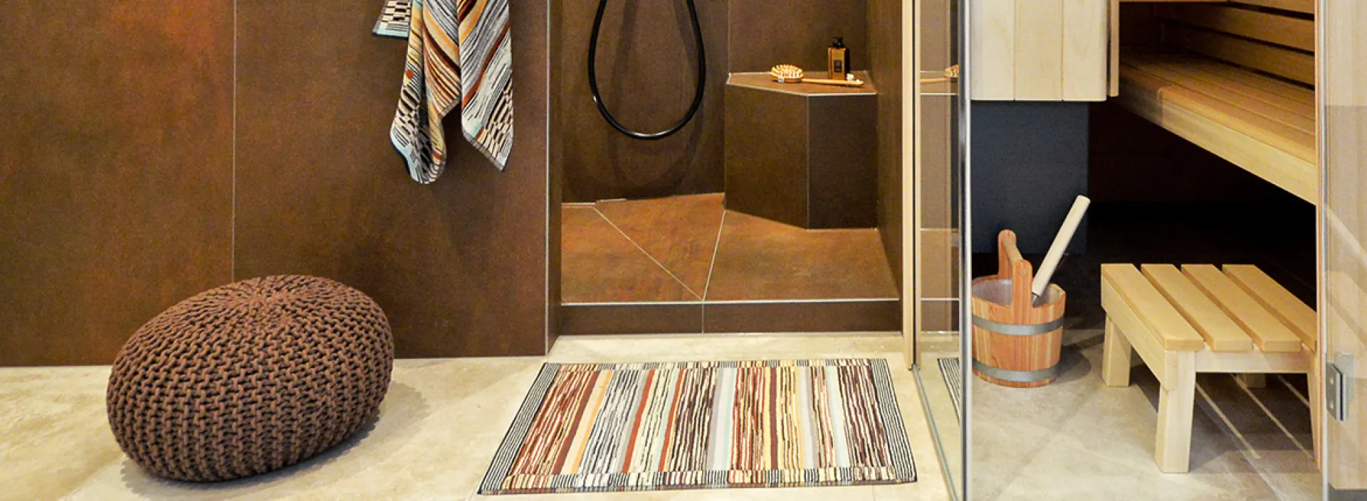 Ein Wellnessbad mit einer Sauna sowie Dusch- und Ruhebereich.