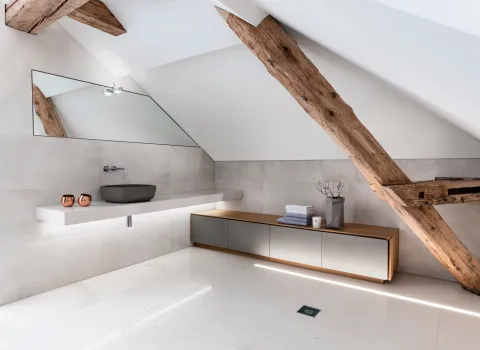 Ein helles Badezimmer mit Holzbalken.