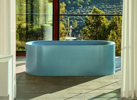 Badewanne BetteLux in Blau-Satin mit Blick durch Baumwipfel