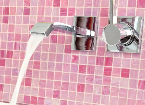 Eine Wandarmatur von Dornbracht vor pinken Wandfliesen.