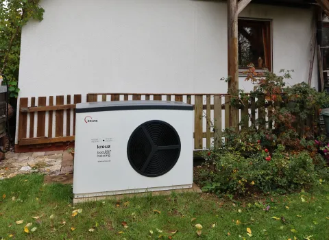 Eine SolvisLea Wärmepumpe vor einer Doppelhaushälfte mit Photovoltaikmodulen am Dach.