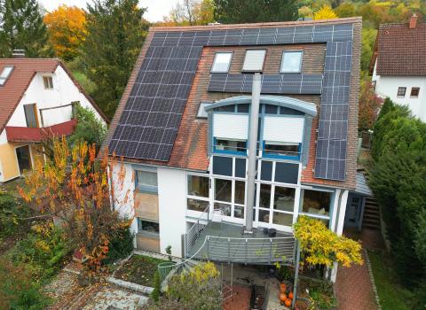 Eine Photovoltaikanlage auf einem Haus mit Erker und Dachflächenfenstern.