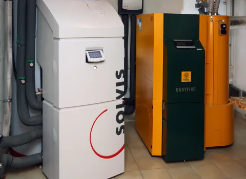 EinSolvisMax Schichtenspeicher und eine KWB Easyfire Pelletheizung nebeneinander im Heizraum.