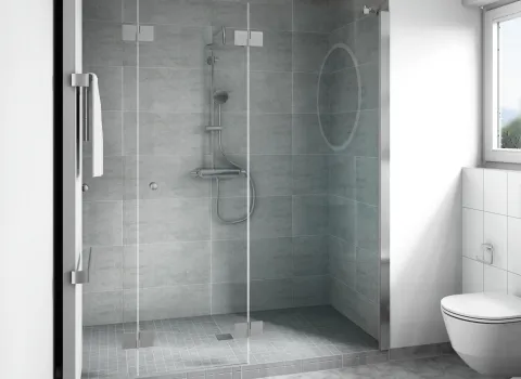 Eine großzügige begehbare Dusche mit rahmenloser Glasabtrennung erstreckt sich über die gesamte Wandbreite des Badezimmers.