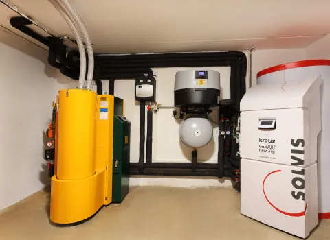 Heizraum mit KWB Pelletheizung, Warmwasser-Wärmepumpenmodul, Solvis-Pufferspeicher und angeschlossener Heiztechnik.