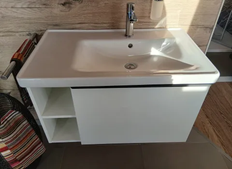 Ein Duravit Waschtisch mit weißem Unterschrank und zwei offenen Fächern 