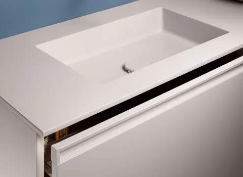 Detail eines Stocco Waschtisches mit integriertem Becken, schmaler Griffleiste und leicht geöffnetem Schubfach.