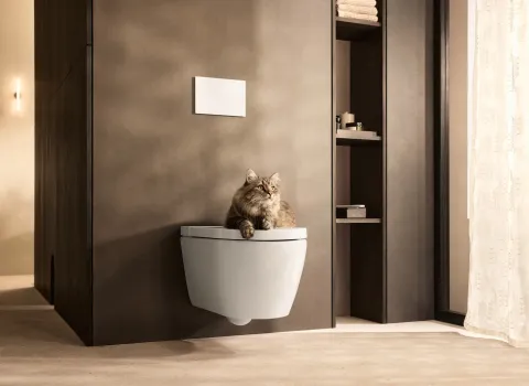 Duravit SensoWash® Starck f Dusch-WC als wandhängendes WC in modernem Badezimmer mit sitzender Katze auf dem geschlossenen Deckel.