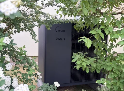 Außeneinheit einer Luft-Wärmepumpe im Garten eines Wohnhauses in Eckental.