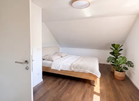 Helles Schlafzimmer im Dachgeschoss nach der Wohnraumsanierung in Eckental.