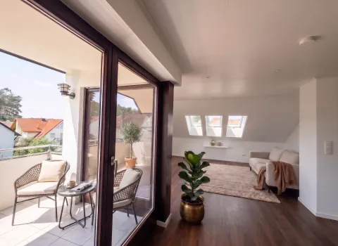 Heller Wohnbereich mit Balkon und Dachfenstern nach der Wohnraumsanierung in Eckental.