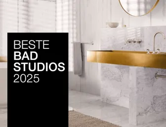 Ein stilvolles Bad mit goldenen Armaturen, Marmorwaschtisch und freistehender Badewanne. Ein schwarzer Banner mit "Beste Badstudios 2024" ist prominent im Bild.