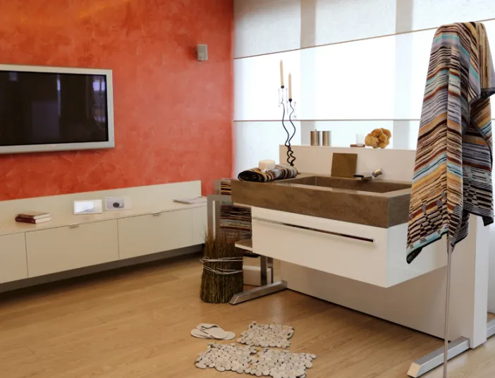 Referenzfoto vom Malerbetrieb Frank von einem Badezimmer mit Fernseher, Armatur und roter Wand.